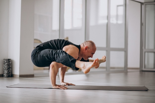 Man practising yoga in the gym