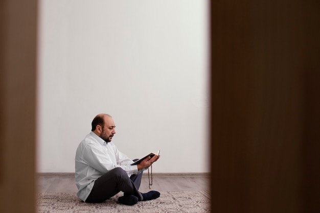 Free photo man praying on the floor indoors