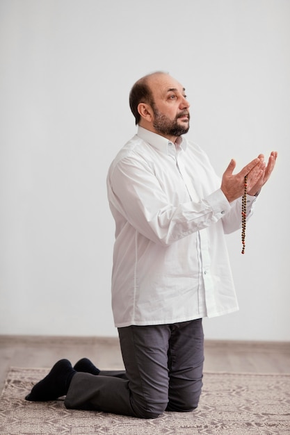 Free photo man praying on the floor indoors