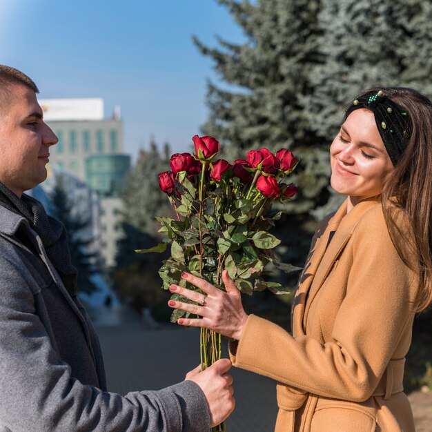 Man presenting bouquet of flowers to smiling woman