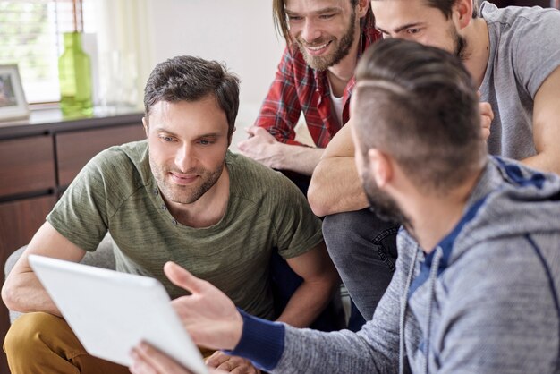 Man presenting to friends his new tablet