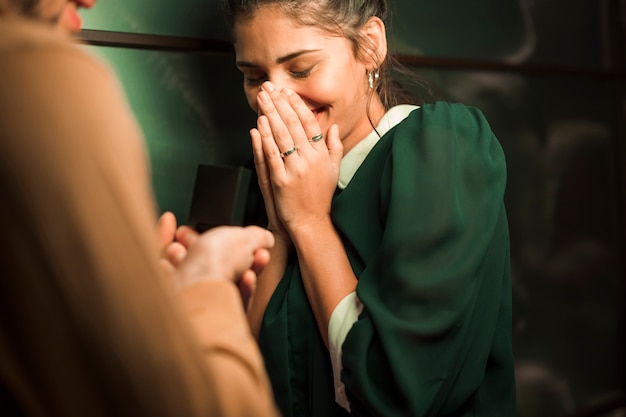 Man presenting gift in box to young amazed woman