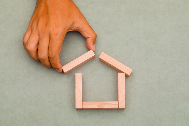 man pulling out wooden block.