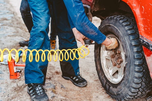 Free Photo man pumps air wheel with a compressor