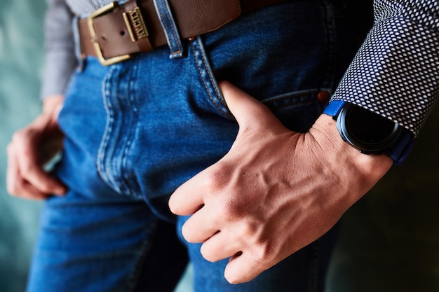 Free Photo man puts his thumbs into the pockets of jeans