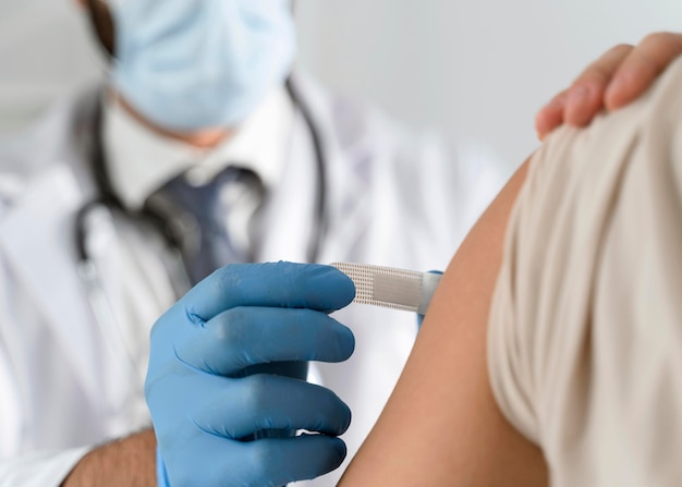 Free photo man putting a bandage on a young woman's arm