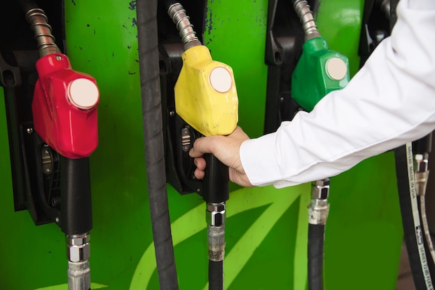 Free Photo man putting gasoline fuel into his car in a pump gas station