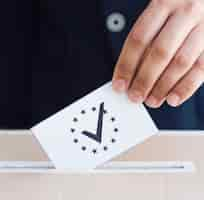 Free photo man putting his ballot in a box close-up