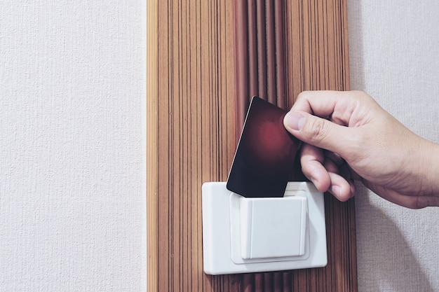 Free Photo man putting key card switch in hotel room