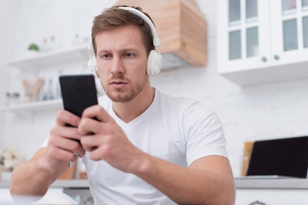 Free photo man putting music from his phone