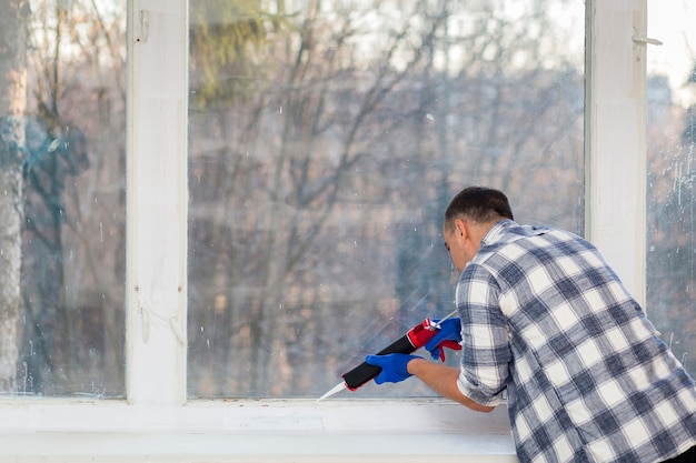 Free Photo man putting silicone on a wall