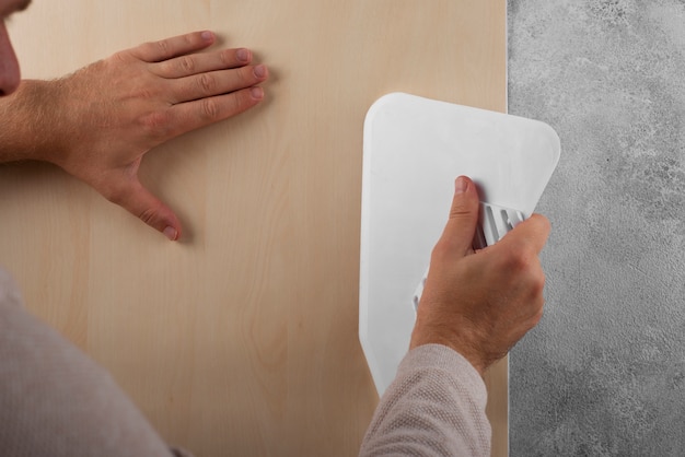 Man putting up decorative vinyl with tool