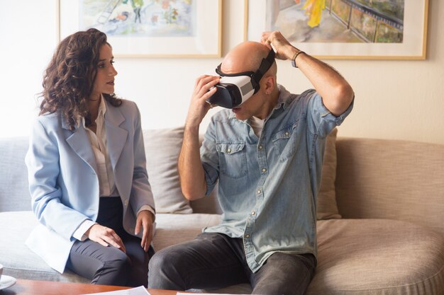 Man putting on VR headset for watching presentation