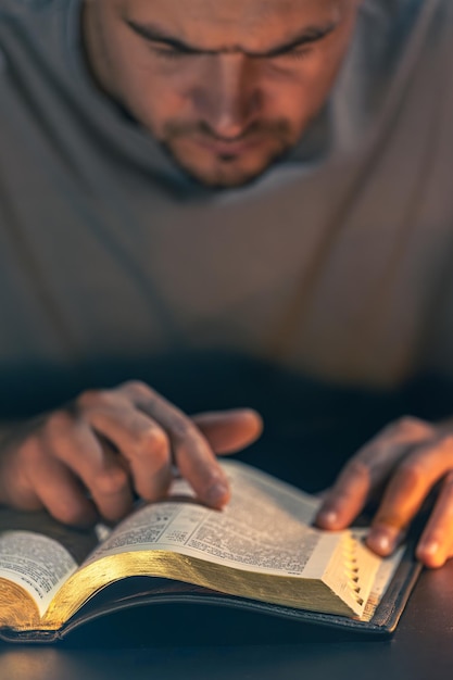 Free Photo a man reads the bible male hands with bible closeup