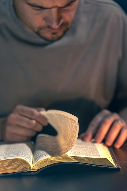 Free Photo a man reads the bible male hands with bible closeup