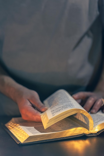 Free photo a man reads the bible male hands with bible closeup