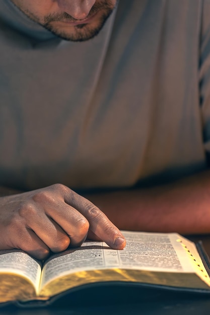 Free Photo a man reads the bible male hands with bible closeup