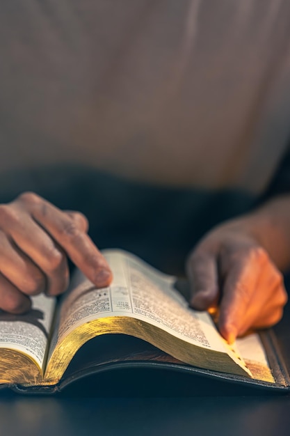 Free Photo a man reads the bible male hands with bible closeup