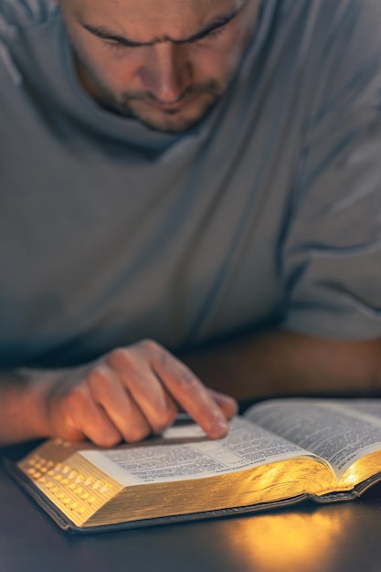 Free photo a man reads the bible male hands with bible closeup