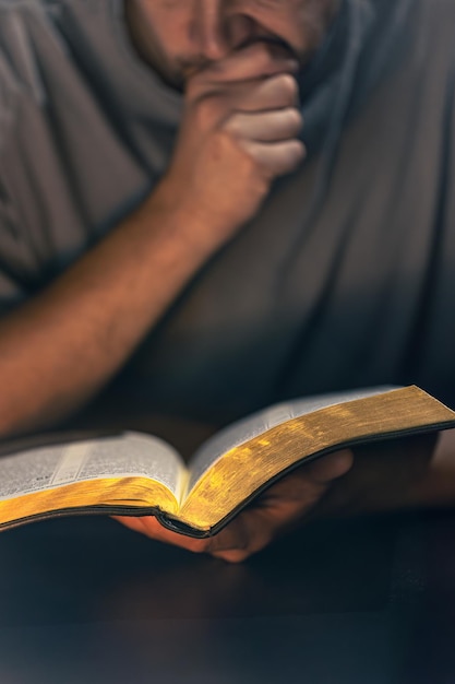 Free Photo a man reads the bible male hands with bible closeup