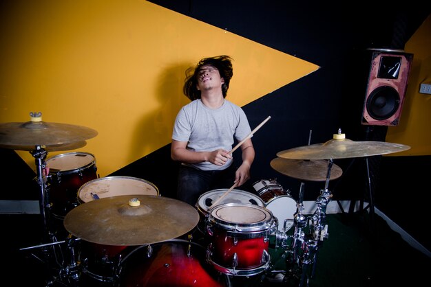 Man recording music on drum set in studio