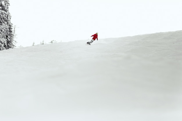 Man in red ski suit executes a heel-side turn 