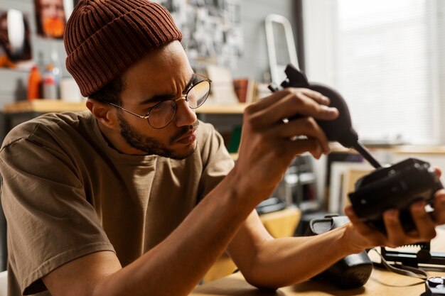 Man repairing photo camera side view