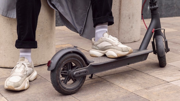 Man resting his foot on electric scooter outdoors