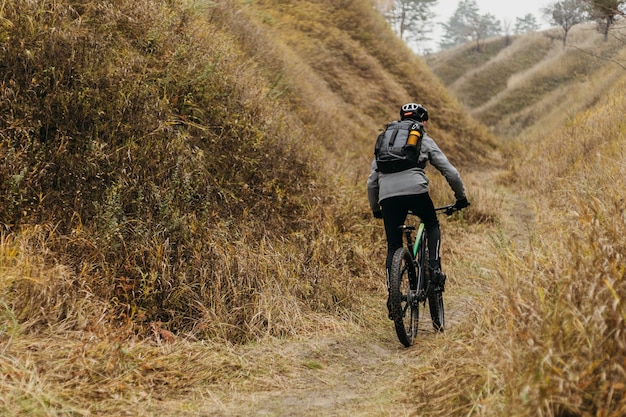 Free photo man riding a bike on mountain path