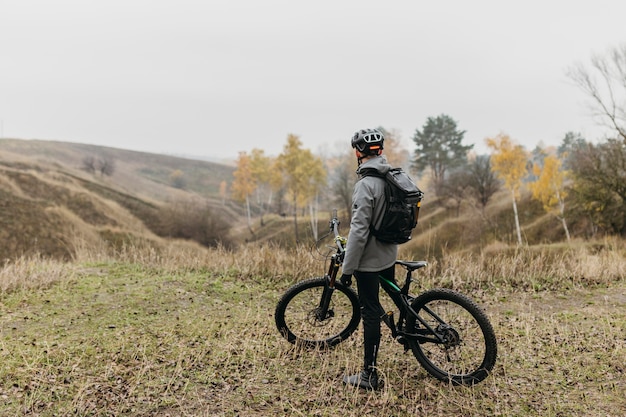 Free photo man riding a bike on mountain path