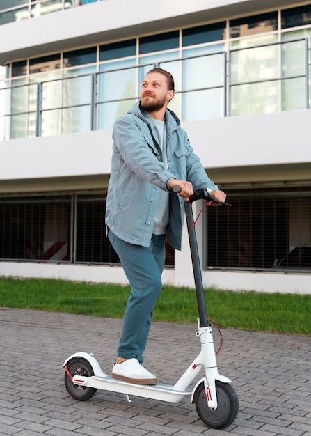 Free photo man riding a scooter outdoors