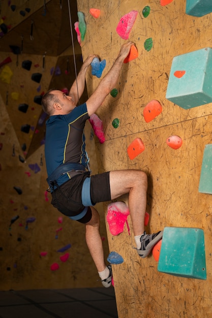 Free Photo man rock climbing indoors in the arena