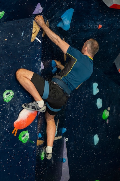 Man rock climbing indoors in the arena