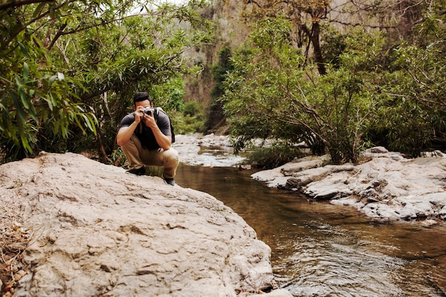 Free photo man on rock at river