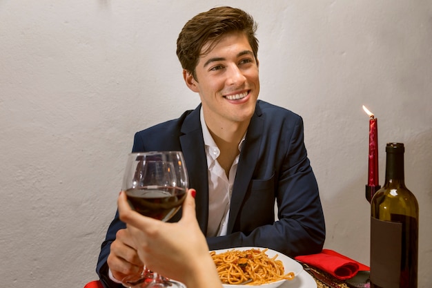 Man in a romantic dinner toasting with wine