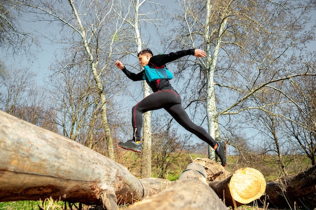 Free photo man running in a park or forest against trees space