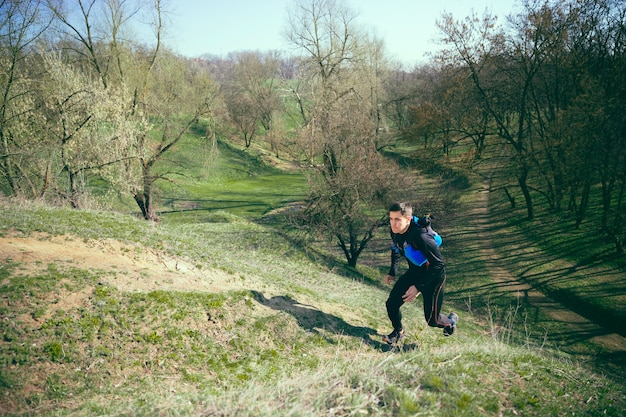 Free photo man running in a park or forest against trees