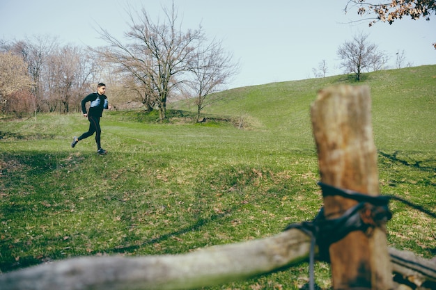 Free Photo man running in a park or forest against trees 