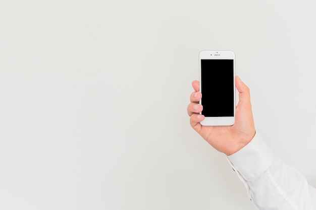 Free Photo man's hand holding smartphone against white background