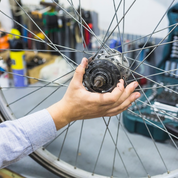 Free Photo man's hand repairing bicycle tire in workshop