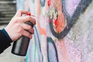 Free photo man's hand spraying red paint with spray bottle