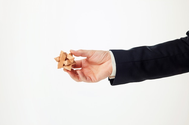 Man's hands holding wooden puzzle.