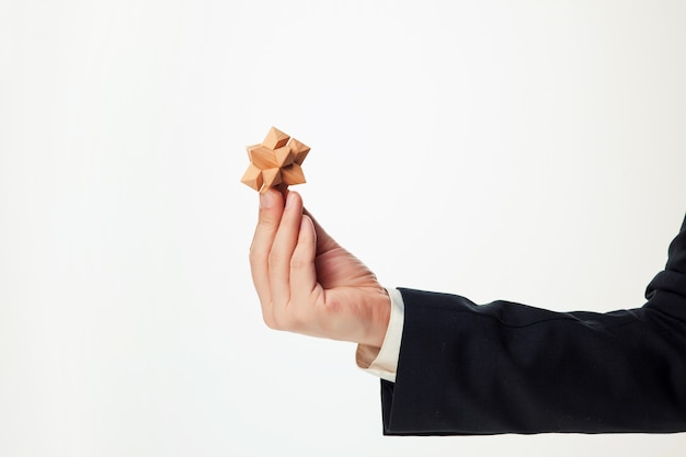 Man's hands holding wooden puzzle.