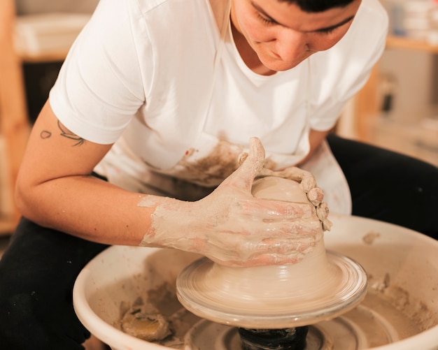 Free photo man's hands making ceramic pot on the pottery wheel