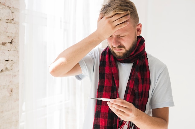 Free photo man in scarf having fever