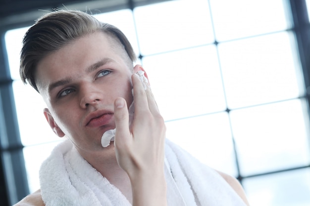 Free photo man shaving his beard