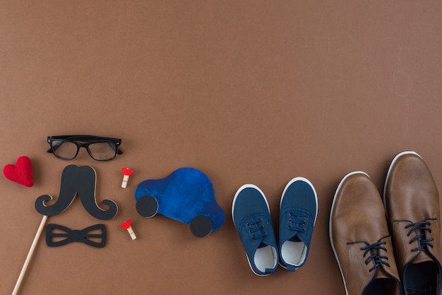 Free photo man shoes with glasses and paper mustache on table