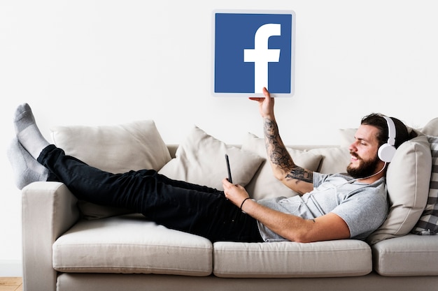 Free Photo man showing a facebook icon