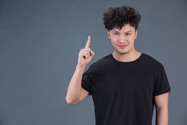 Man showing hand gesture in studio behind posing