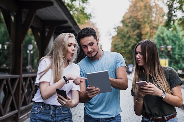 Man showing a post on tablet to his friends